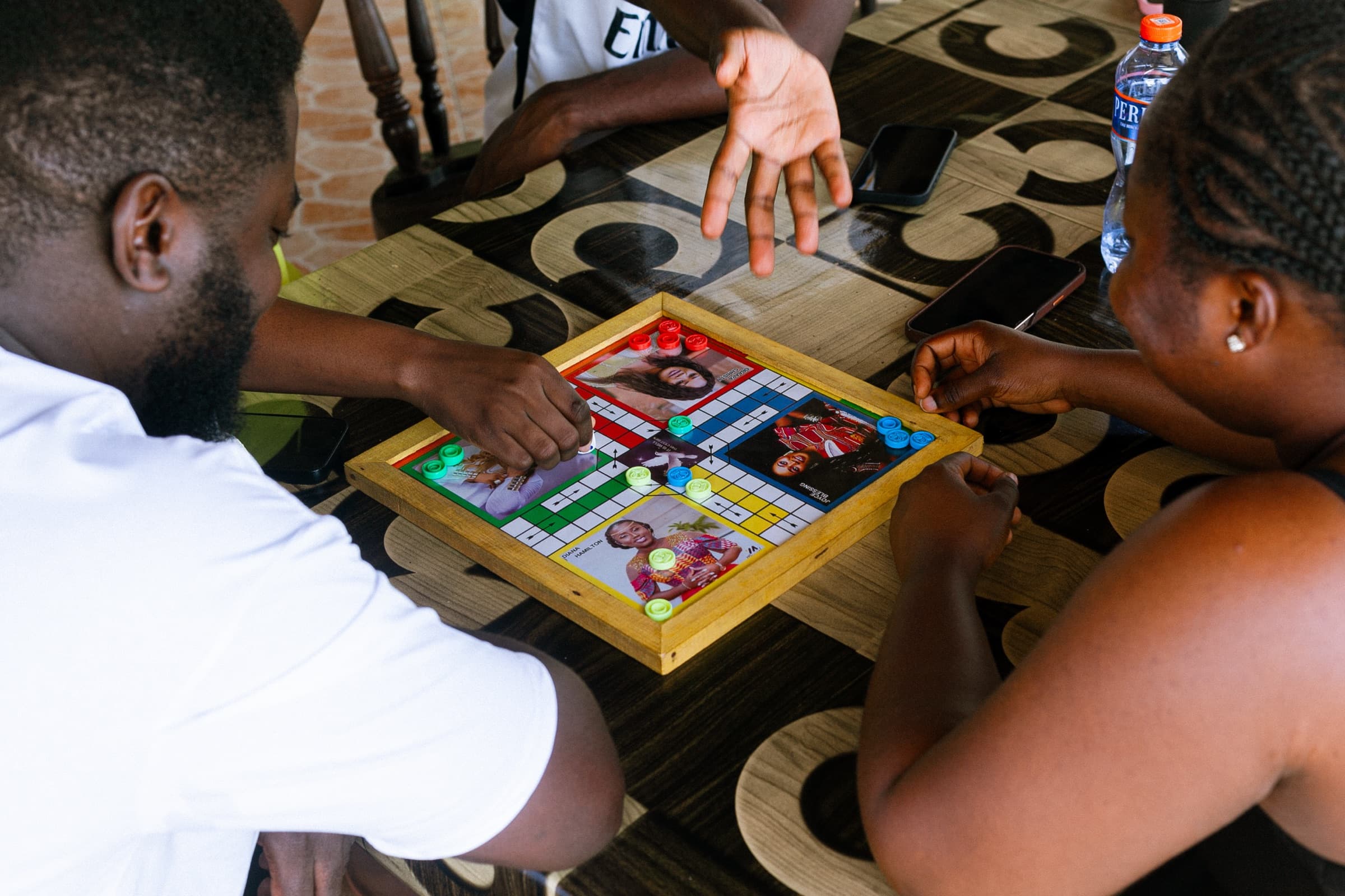 Guests gathered around a Ludo board during a FAYA Escape game night