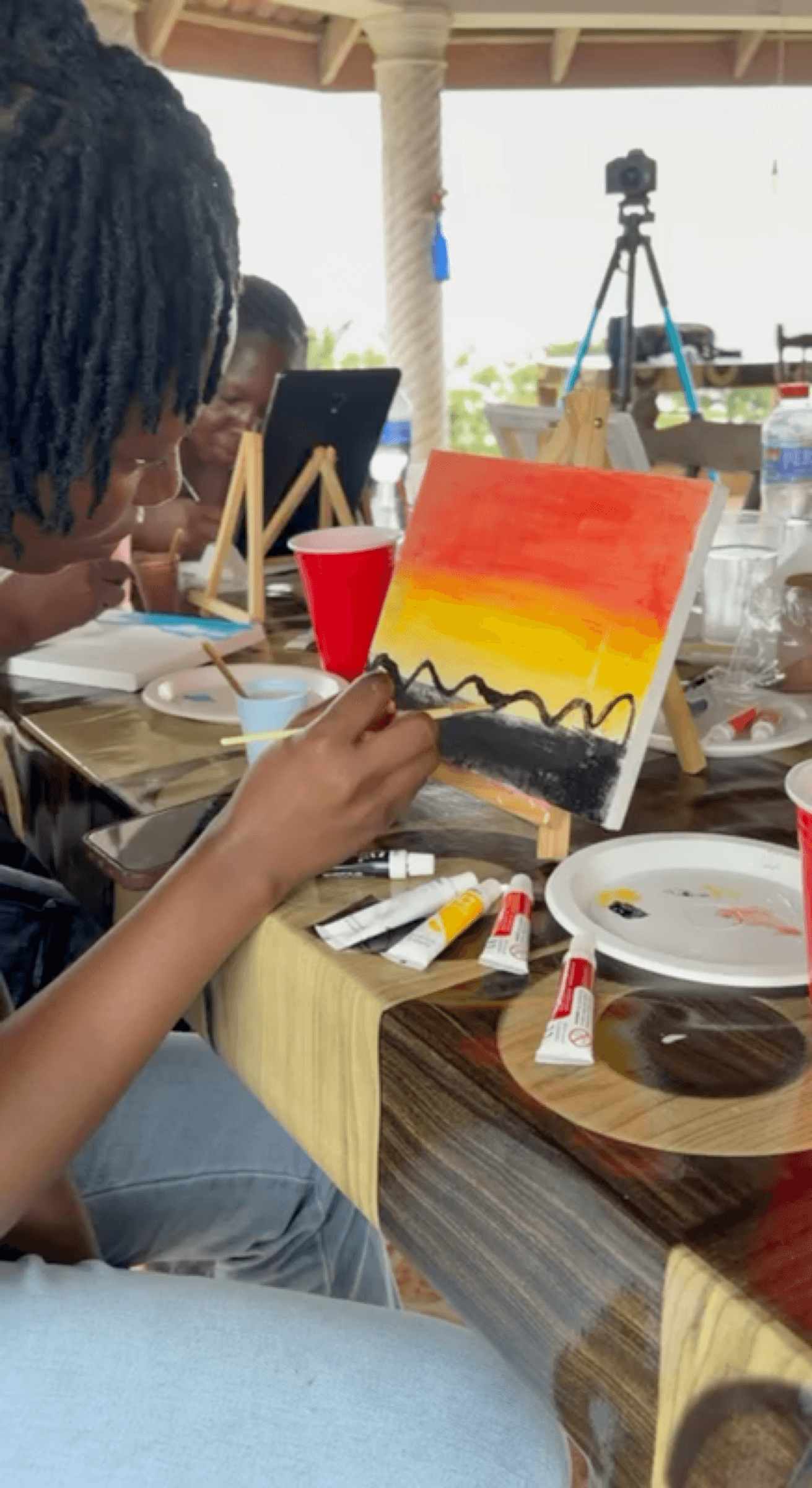 Guests painting on easels at a FAYA Escape sip-and-paint session