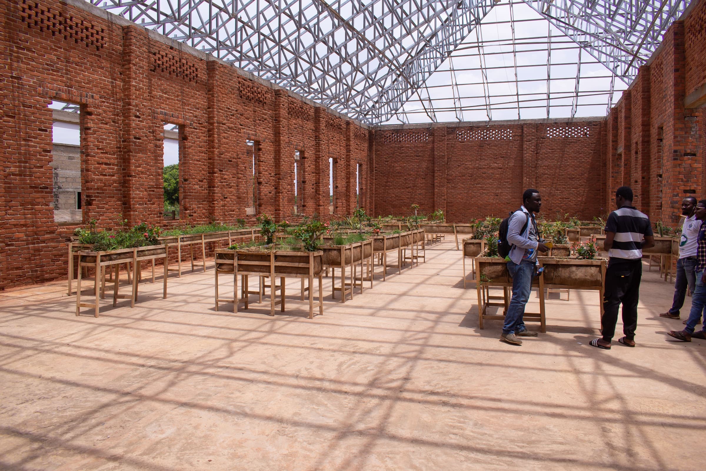 Visitors inside the brick-and-steel exhibition hall at SCCA, Tamale