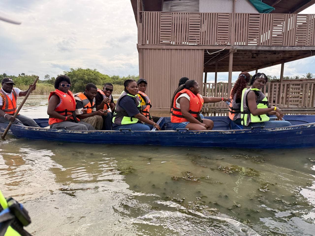The group paddling a canoe across the water